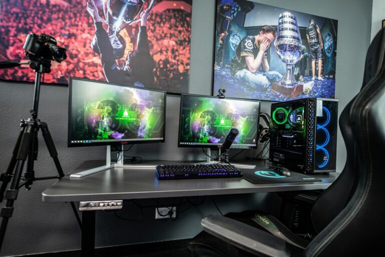 Ein Gaming-Schreibtisch mit zwei Monitoren, einem Computer-Tower und einer Kamera auf einem Stativ
