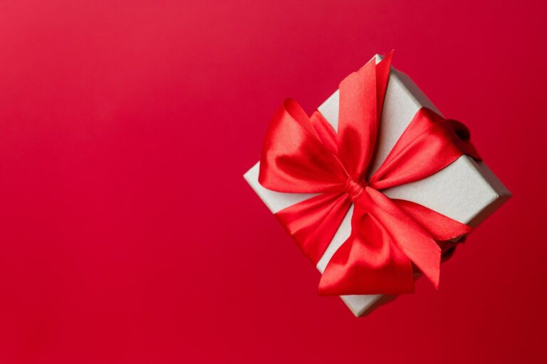 Wrapped gift with ribbons on a light surface