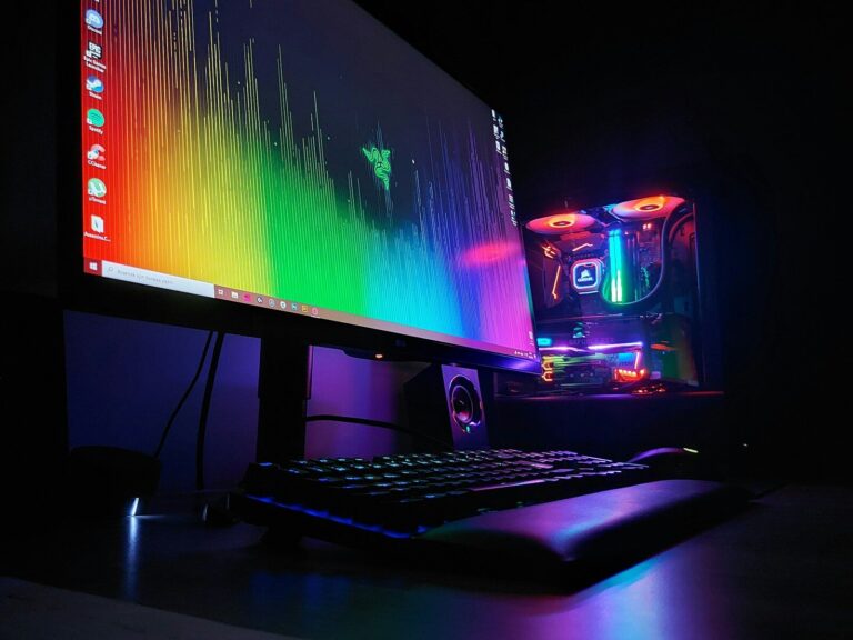 Streaming-Schreibtisch mit Mikrofon, Tastatur und Monitor im abgedunkelten Raum