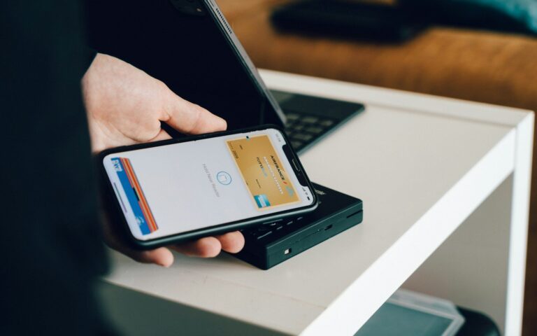 Hand hält ein Smartphone, auf dem eine Bezahl-App geöffnet ist