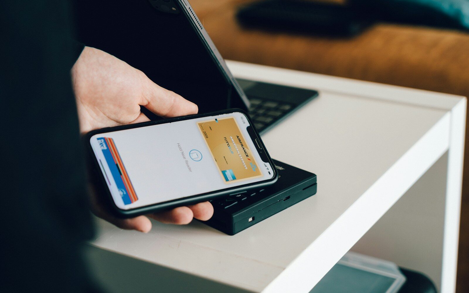 Hand hält ein Smartphone, auf dem eine Bezahl-App geöffnet ist